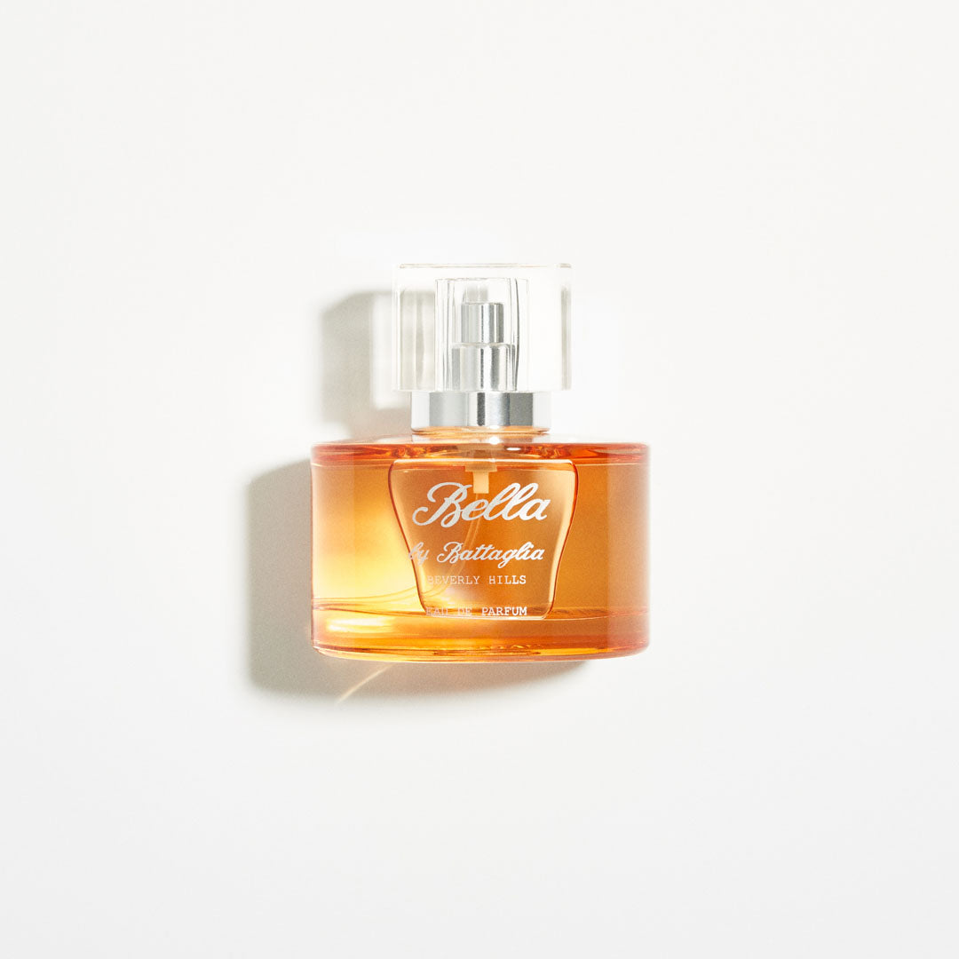 A photo of the Bella fragrance sample by Battaglia. The sample is standing upright next to the orange box it is packaged in against a white background.