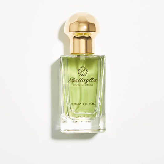 A photo of the Essenza per Uomo fragrance by Battaglia against a white background. The bottle is rectangular with a light green liquid and a gold circular cap.