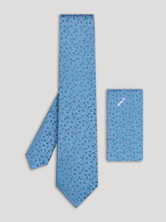 Sky blue tie with green and red floral details and matching handkerchief.