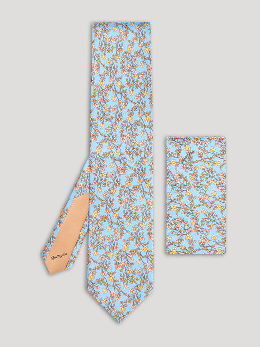 Light blue tie with yellow and orange floral details and matching handkerchief.