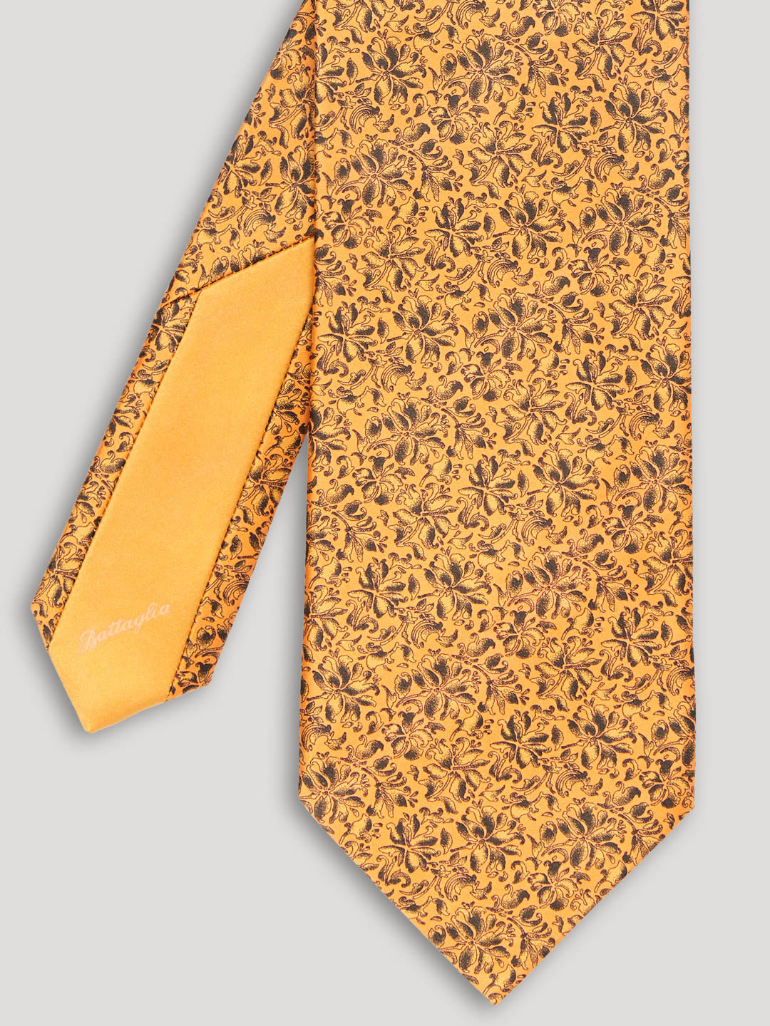 Golden yellow tie with black floral details. 