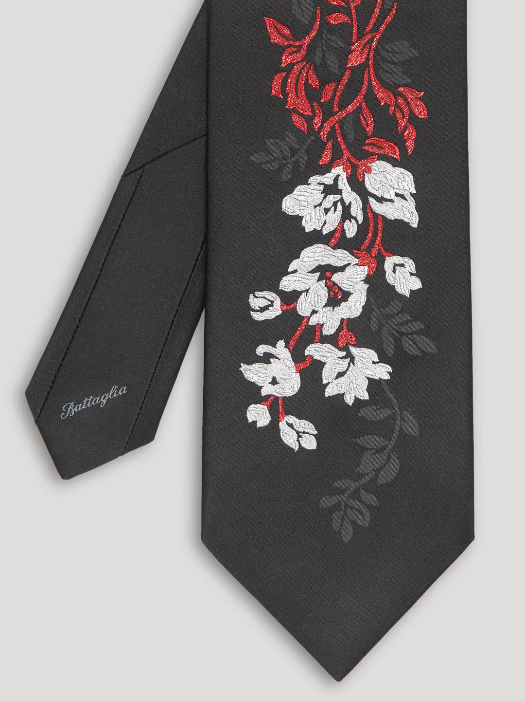 Black tie with silver and red woven floral details. 
