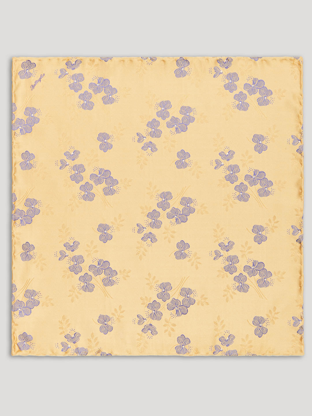 Yellow handkerchief with purple flowers on it.