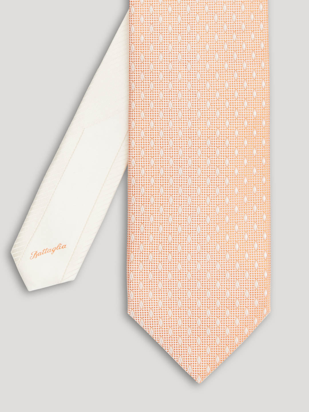 Peach tie with white diamond details on it.