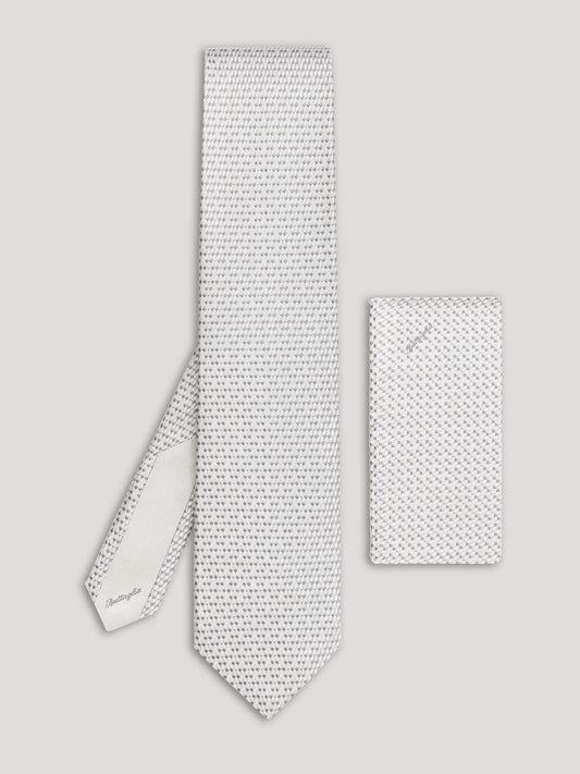 Silver tie with small grey geometric details and matching handkerchief. 