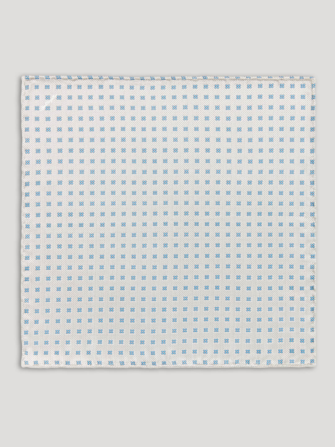 Silver handkerchief with blue diamonds on it.