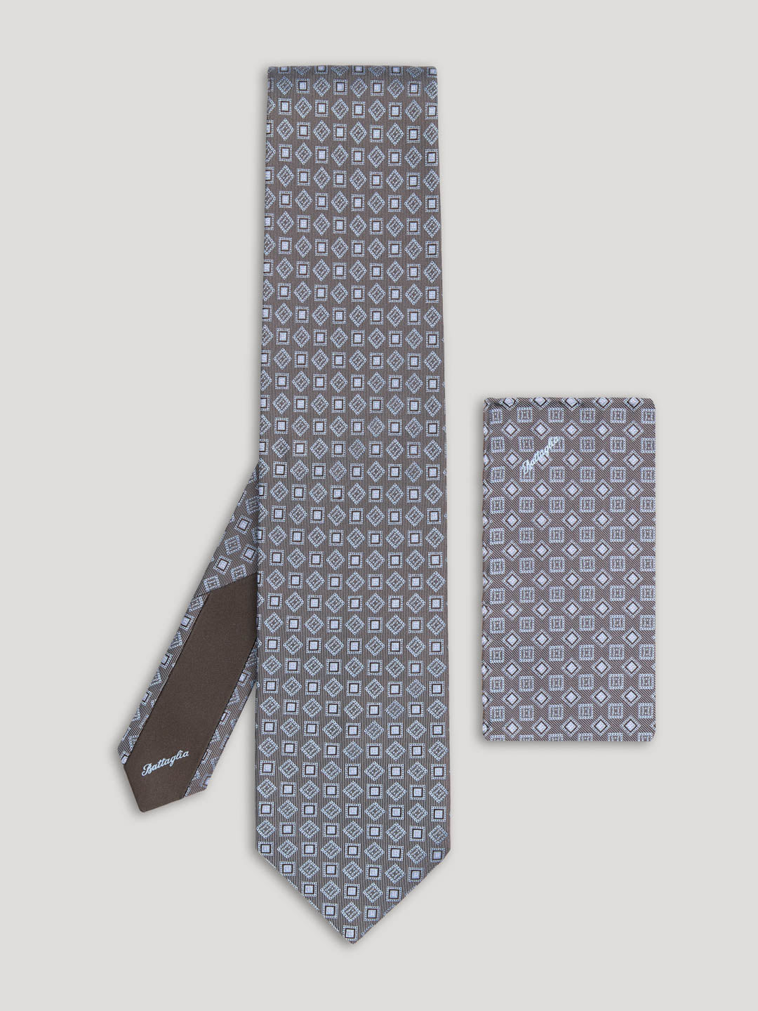 Grey tie with diamond and square design and matching handkerchief.