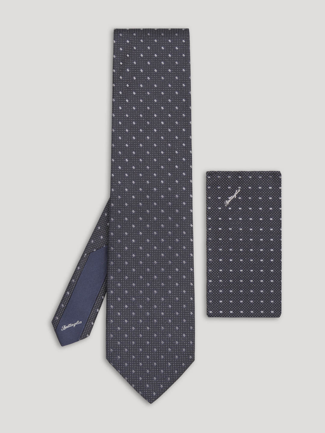 Black tie with silver geometric design and matching handkerchief.