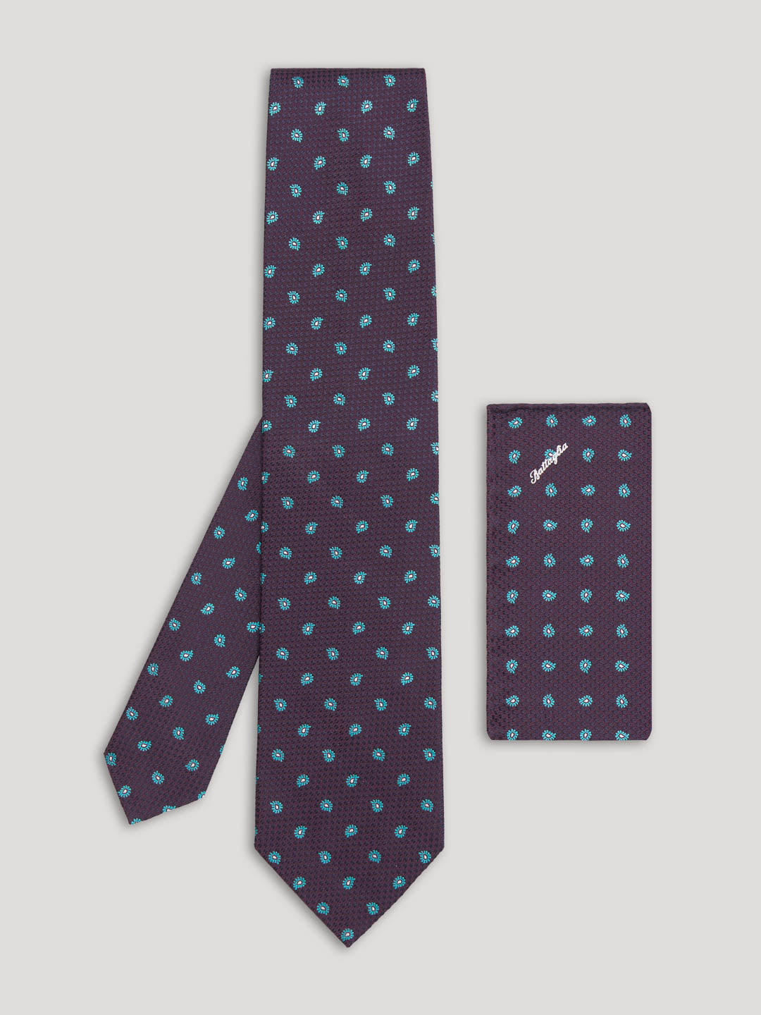 Purple tie with small blue paisley design and matching handkerchief.