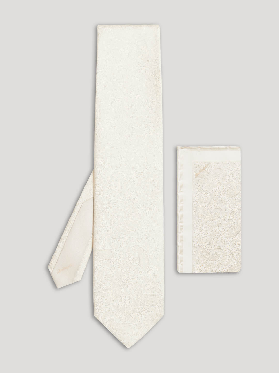 Cream white paisley silk tie with matching handkerchief.