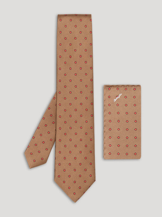 Brown tie with small red polkadots and matching handkerchief.
