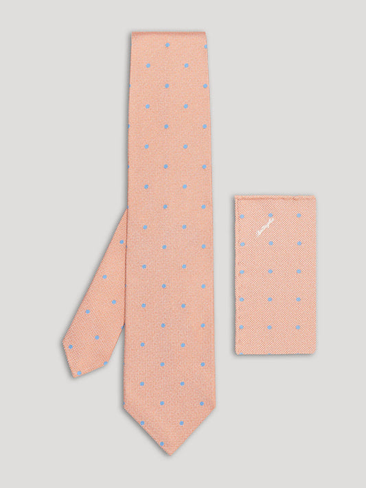Light orange tie with blue polkadots and matching handkerchief.