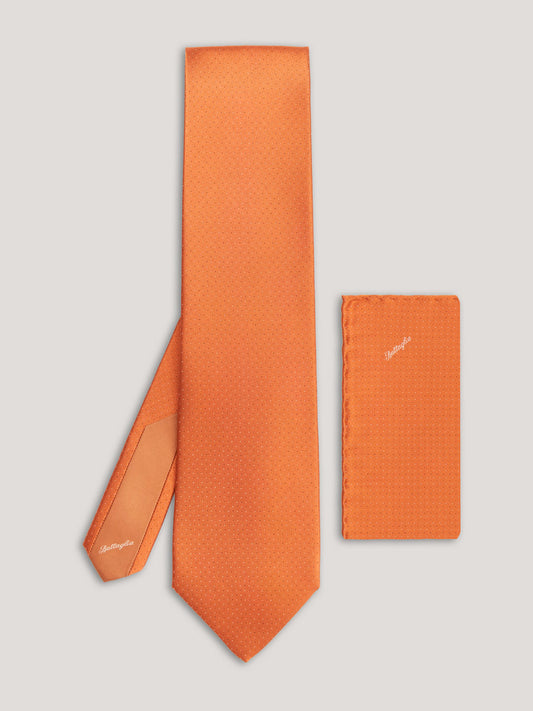 Orange tie with small pattern and matching handkerchief.