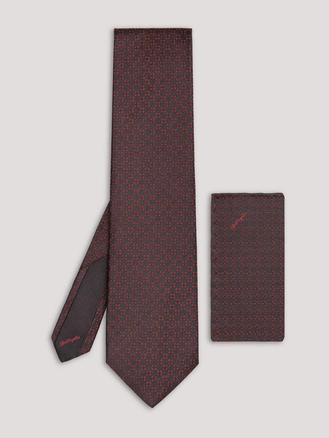 Red and black tie with small pattern and matching handkerchief.