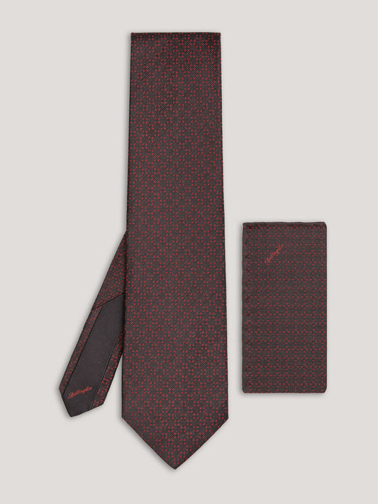 Red and black tie with small pattern and matching handkerchief.