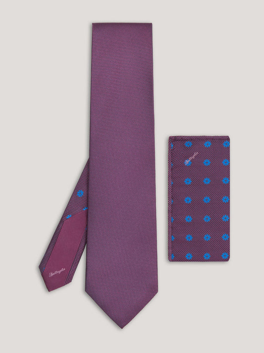 Purple tie with blue pattern and matching handkerchief. 