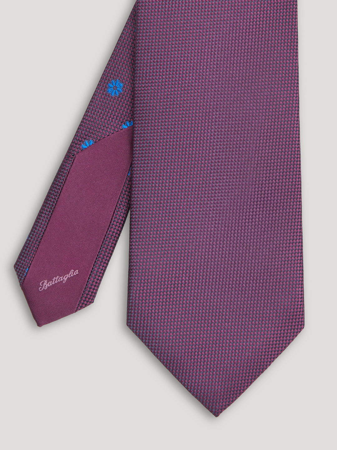 Purple tie with blue small pattern design. 