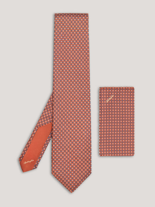 Orange tie with blue small pattern design and matching handkerchief. 