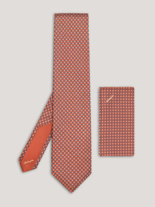 Orange tie with blue small pattern design and matching handkerchief.