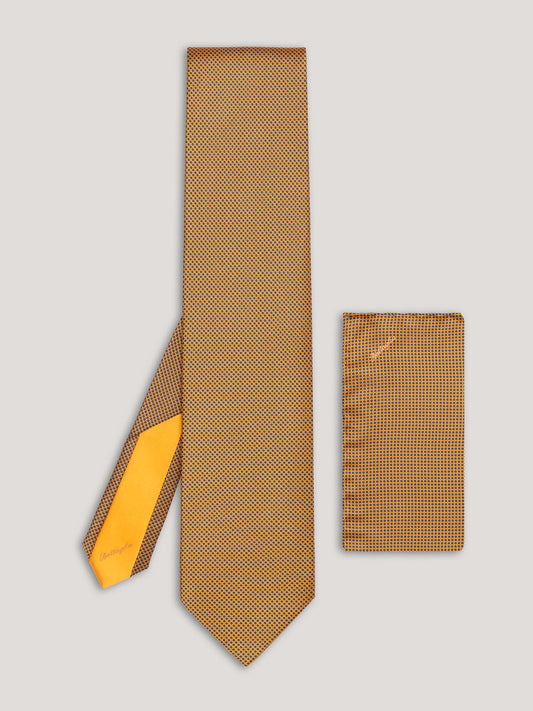 Yellow tie with small black pattern design and matching handkerchief. 