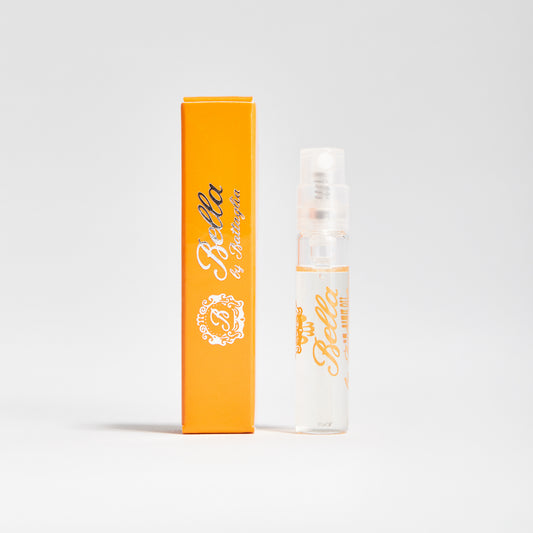 A photo of the Bella fragrance sample by Battaglia. The sample is standing upright next to the orange box it is packaged in against a white background.