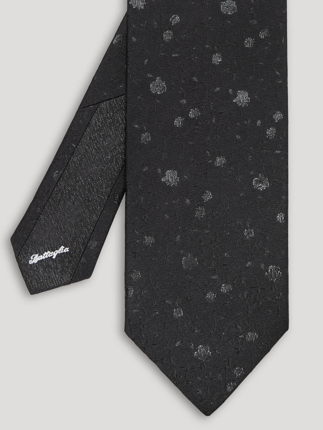 Black silk tie with silver floral details. 