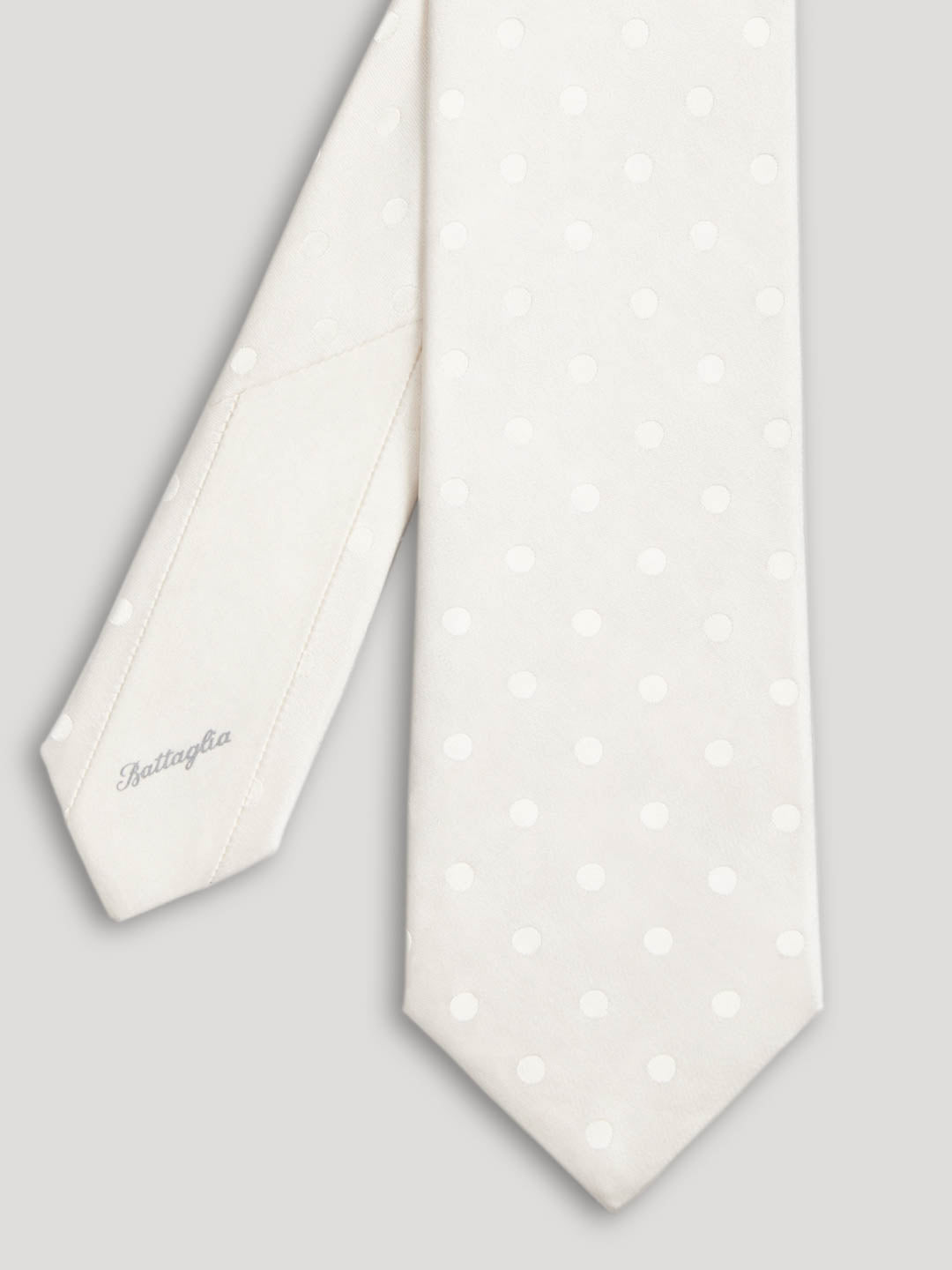White silk tie with polkadots.