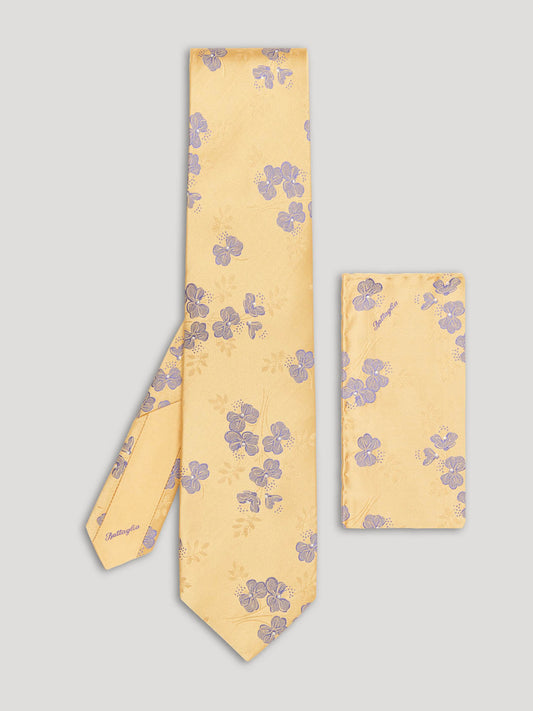 Yellow tie with purple flowers and matching handkerchief. 