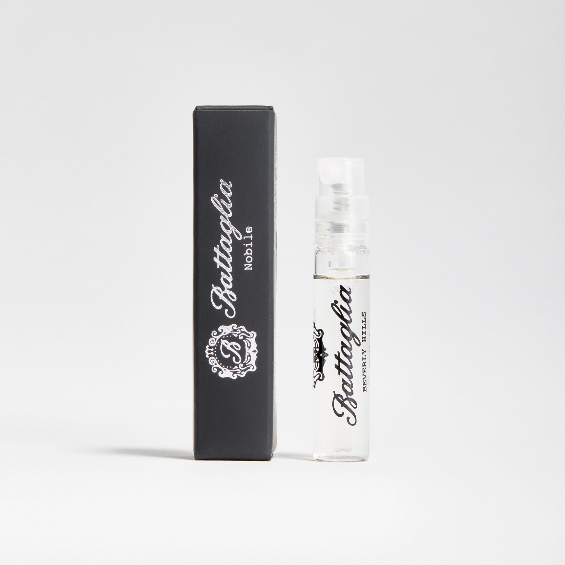A photo of the Nobile fragrance sample by Battaglia. The sample is standing upright next to the black box it is packaged in against a white background.