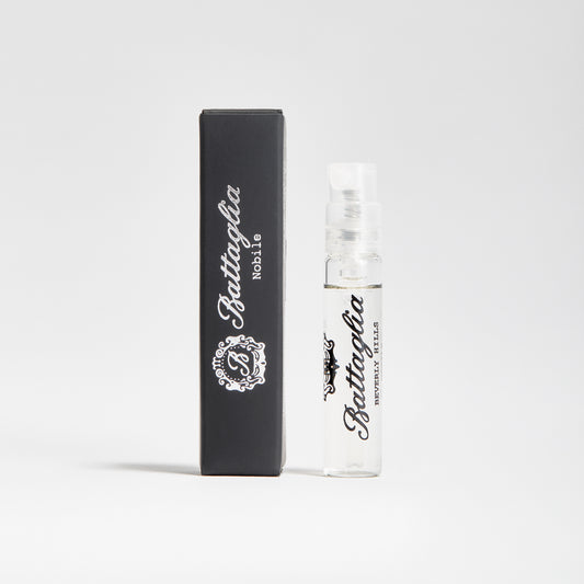 A photo of the Nobile fragrance sample by Battaglia. The sample is standing upright next to the black box it is packaged in against a white background.